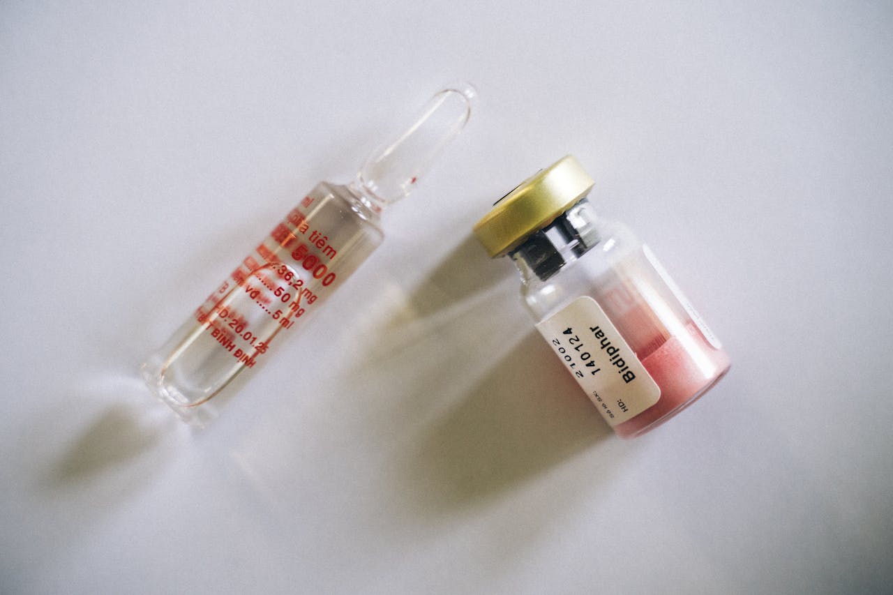 Top view of a medical ampoule and vial on a white background, perfect for healthcare themes.